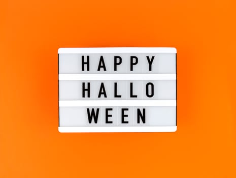 Light box with Happy Halloween on an orange background. photo