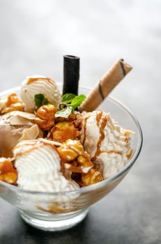 Caramel and almond ice cream with caramelized popcorn sundae dessert in glass bowl photo