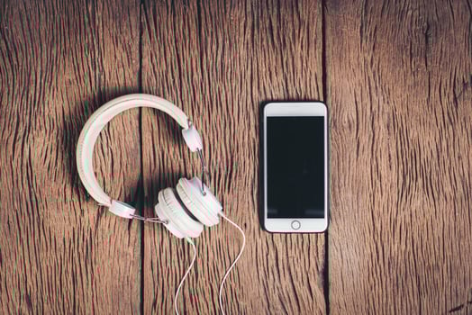 Top view phone and headphone wood background. photo