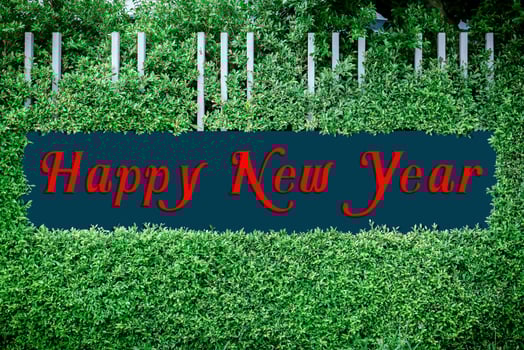 Happy new year texts logo on the framed by green leaves photo