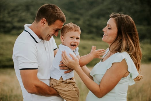 Young family with cute little boy having fun outdoors in the field photo