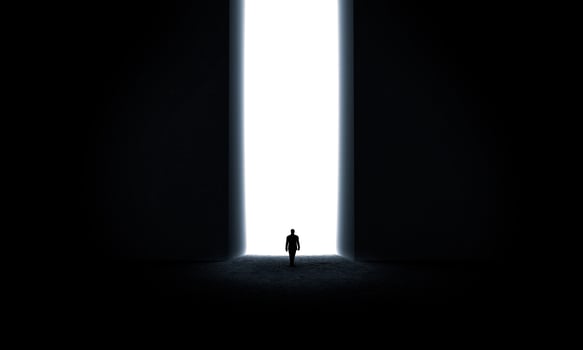 Silhouette of businessman standing in front of lighting door photo
