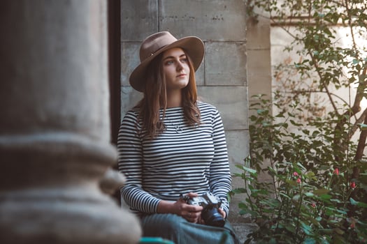 beautiful woman in hat is taking picture with old fashioned camera photo