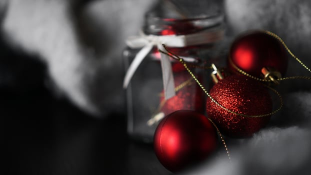 Small red Christmas balls in a glass jar photo