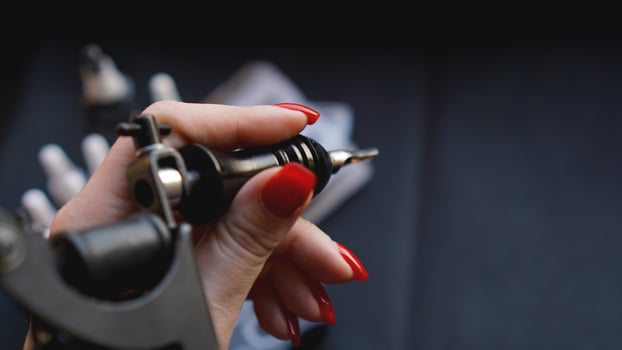 Tattoo artist holding a tattoo machine. photo