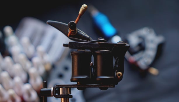 Tattoo machine and tattoo supplies on dark background photo
