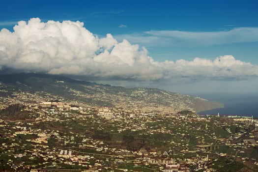 Huge cloud hung over the town on a mountain photo