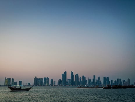 Doha city skyscrapers urban skyline view and dhow boat in Qatar photo