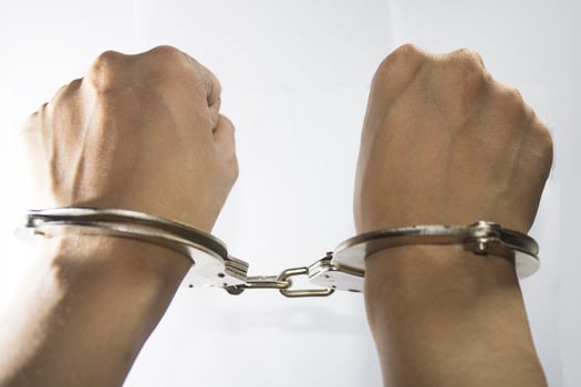 photo of both hands in police steel handcuffs cool shiny white