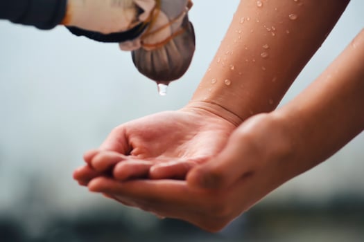 Hand catches water drops coming out of faucet photo