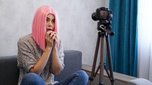 Young female blogger with camera vlogging stressed photo