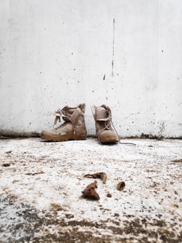 Old military boot on white wall background photo