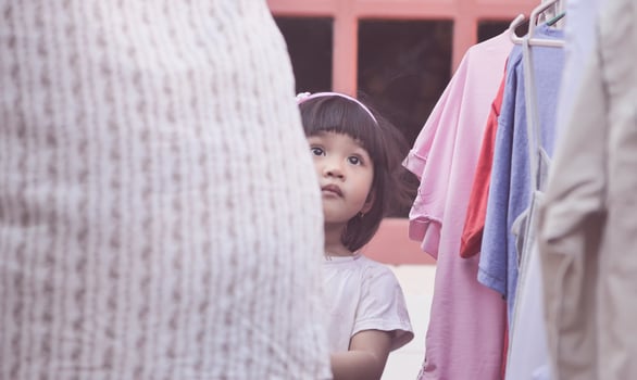 A baby girl accompanies her mother drying clothes. photo