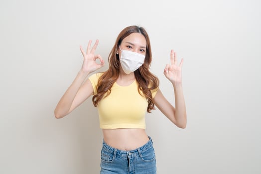 Portrait beautiful woman wearing mask with ok or agree hand sign photo