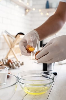 Man hands separating yolk and white of the egg shell in the kitchen photo