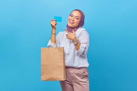Portrait of happy young girl holding shopping bag and credit card photo