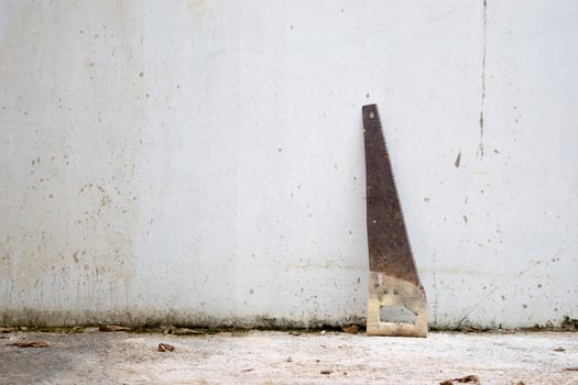 An old hand saw on white wall background photo