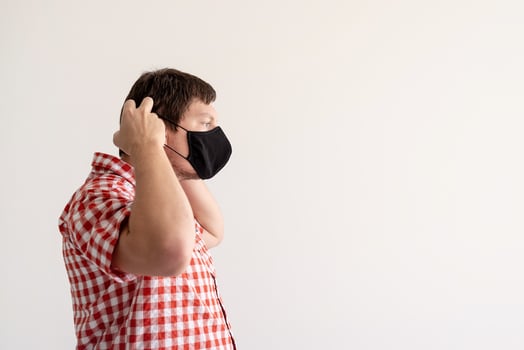 Young man putting on a protective mask photo