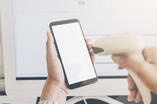 Concept of shopping and hands holding smartphone and barcode reader. photo