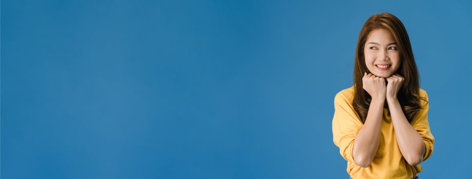 Young Asian lady with positive expression on blue background. photo
