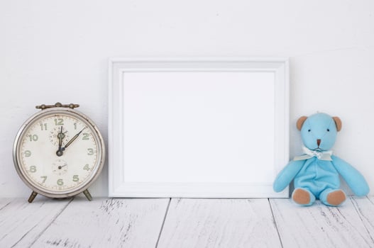 White frame with clock and bear photo