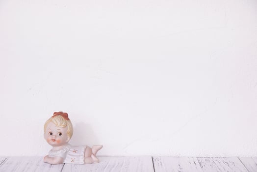 Ceramic doll on white wall photo