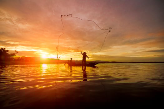 Silhouette Fisherman Fishing by using Net photo