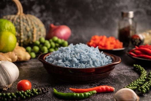 Butterfly Pea flower rice in a brown cup with spices on black cement. photo
