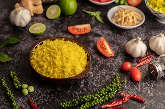 Turmeric rice in a brown cup with spices on black cement. photo
