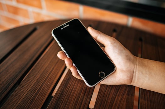 Smart phone on hand with table photo