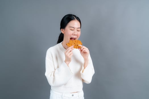 Young asian woman with happy face and enjoy eating fried chicken photo