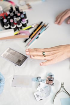 Manicure master in mask and gloves doing stamping to the client photo