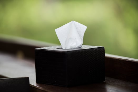 Tissue box black on brown wood bar. photo