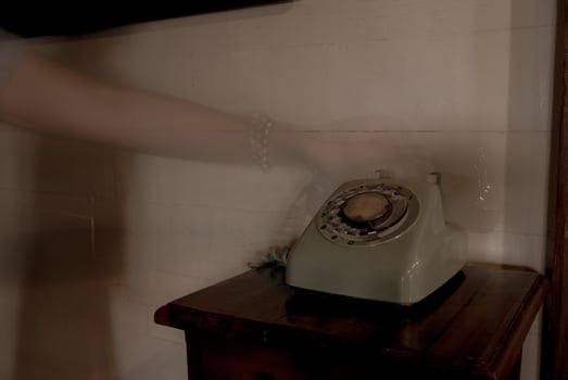 Hand of ghost holding retro telephone headset in old house photo