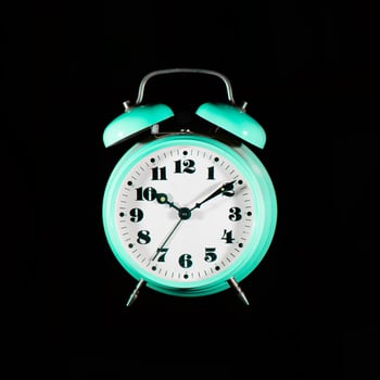 Classic table alarm clock green color on a black background photo