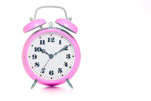 Classic pink table alarm clock on a white background photo