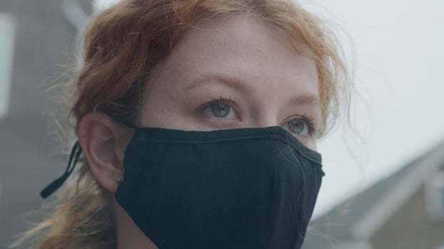 Close up of young white woman standing outside, wearing face mask photo