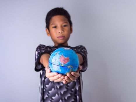 boy holding a globe stand out in front . photo