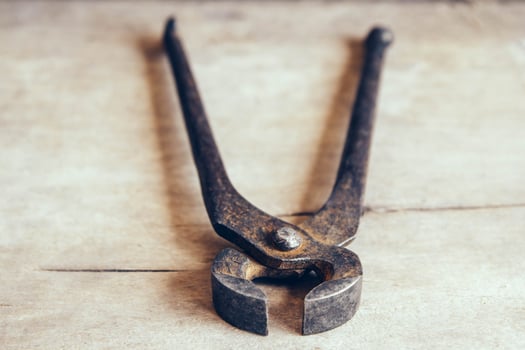 Old rusty pincers on a wooden background photo