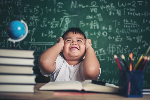 worried boy In classroom with hands on head photo