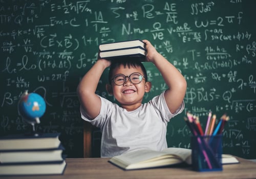 boy with books sitting in the classroom photo