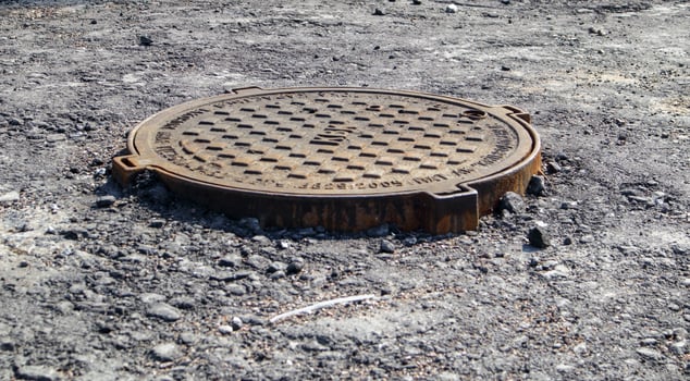 Metal manhole on the road when paving new asphalt. photo