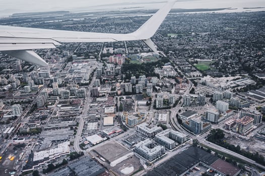 Aerial view of airplane wing on traffic in crowded city photo