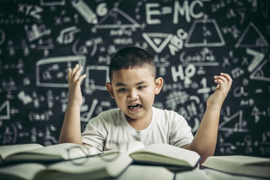 Boys with glasses write books and think in the classroom photo