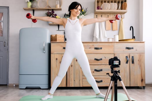 Beautiful, attractive girl trains hands with dumbbells photo