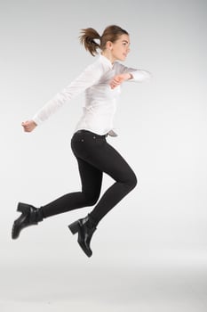 Happy smiling young woman jumping in air - people concept image photo