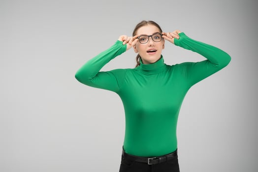 Amasing pretty girl in glasses posing in studio  and looks at the camera with wonder photo