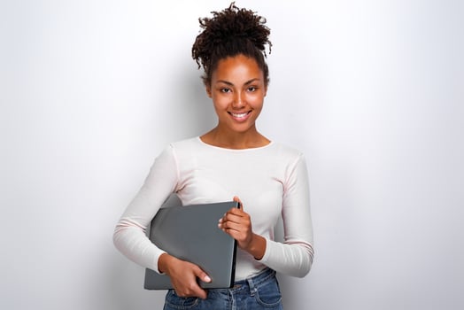 Young girl holding laptop computer while standing in the studio photo