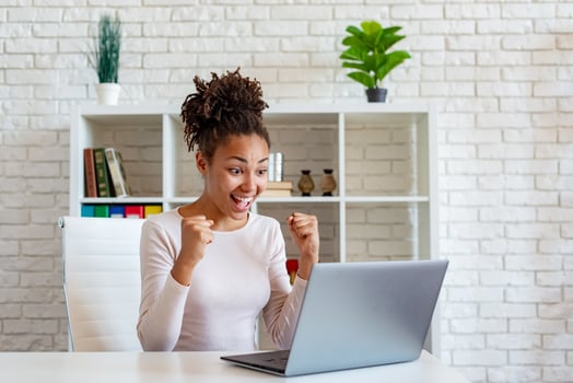 Happy african american woman screams make a winner gesture with clenched fists photo