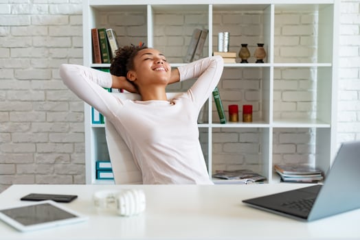 Happy woman have a break in office, folded arms by the head and lying the chair looking up photo
